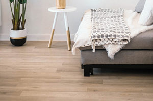 Cool toned laminate plank flooring in a modern bedroom design.