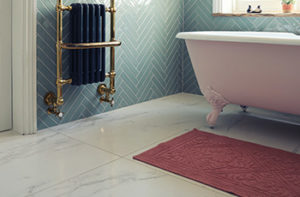 Large format porcelain tiles in a small bathroom with vintage clawfoot bathtub.