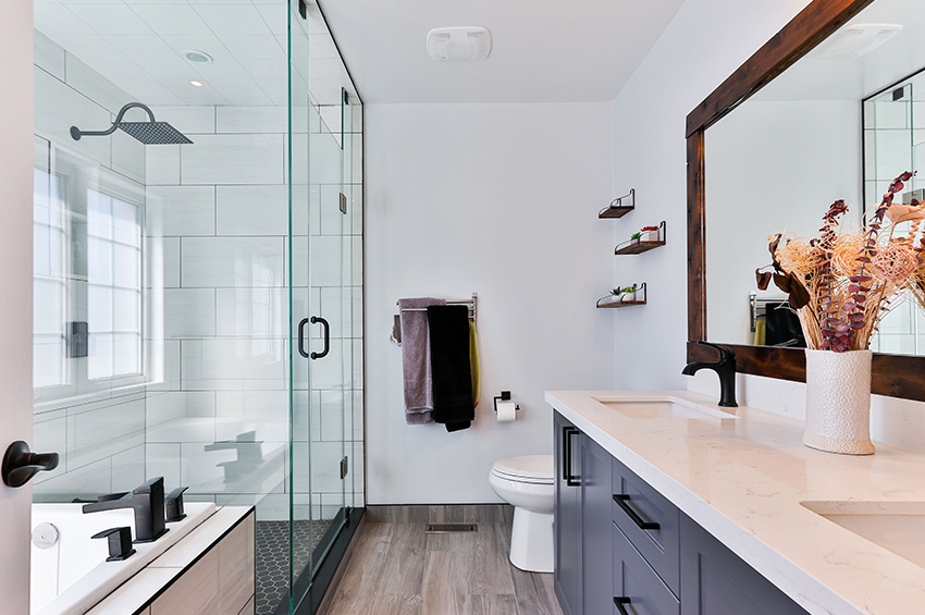 Newly remodeled spa-like bathroom with gray toned luxury vinyl plank flooring.