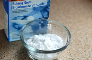 Box of baking soda and some in a glass bowl for cleaning floors
