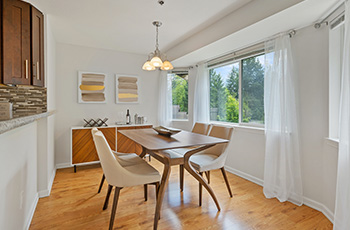 This small, yet bright and airy kitchen, features hardwood flooring, Mid Century Modern furniture, and unique overhead lighting.