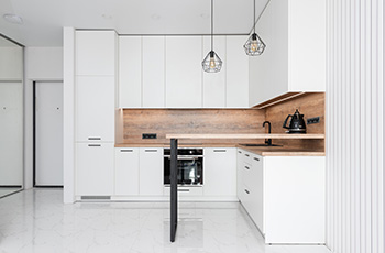 This kitchen has a monochromatic color scheme and all the walls, cabinets, and flooring are white.