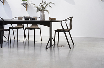 A wood table sits on a polished concrete floor.
