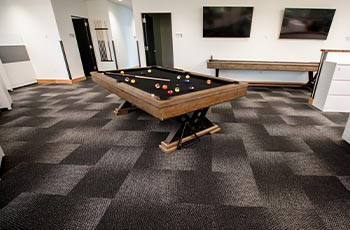 Black, white and gray commercial carpeting in an office break room with pool table.