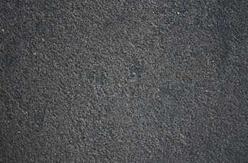 Grey luxury vinyl tile flooring has a cement-like texture.