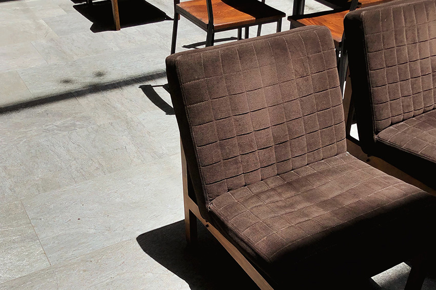 Brown chairs rest on luxury vinyl flooring tiles that look like natural slate flooring.
