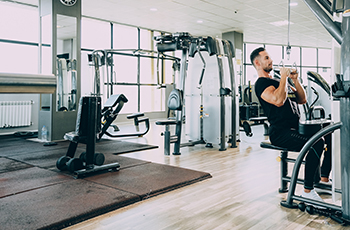 Man works out in a gym with vinyl floors that look like hardwood.