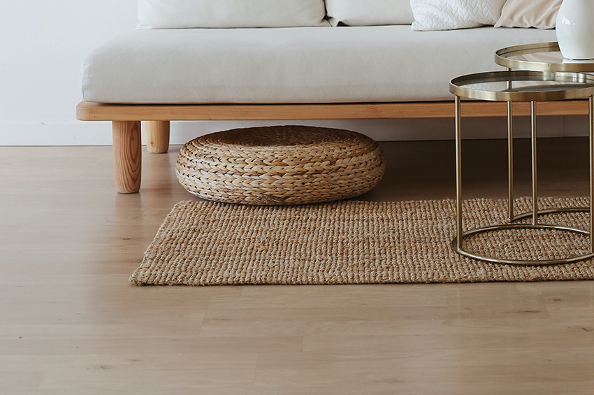 Light-toned hardwood floors are covered by a sisal area rug.