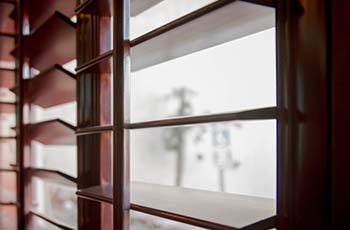 Wood slatted blinds hung in a window.