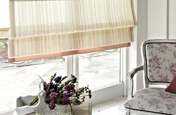 Horizontally striped beige Roman shades complement a country cozy living room design.