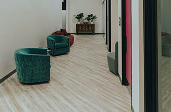 An office hallway has a contemporary design and cork flooring that looks like wood.