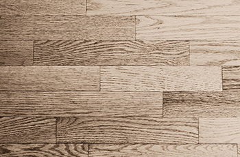 Close up of vinyl plank flooring with a wood grain pattern.
