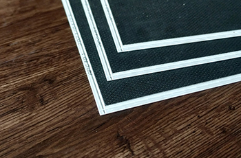 Dark wood flooring has a textured grain finish.