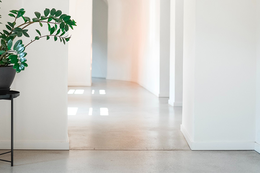 Polished concrete flooring with a white hue is used in an office hallway.