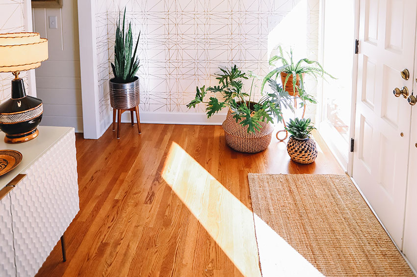 Hardwood flooring in an entryway of a home as well as an area rug made from natural fibers.