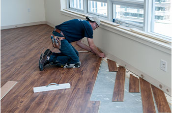 A Floor Factors employee installs hardwood floors.