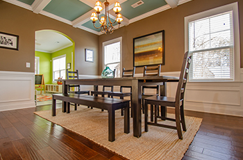 A dining room styled traditionally with wood look flooring.